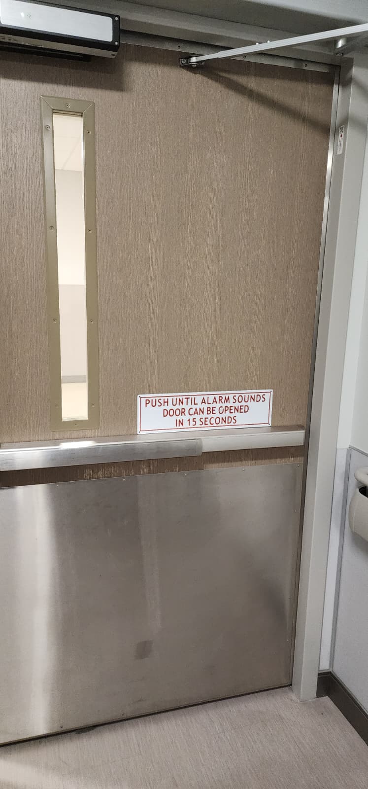 Correct delayed egress instructional signage mounted on the egress side of a door at readable height