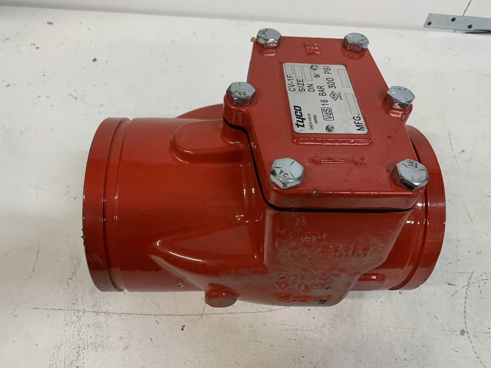 Tyco CV-1F grooved swing check valve — red ductile-iron body, stainless bolts, nameplate showing DN 8 inch size, 300 PSI / 16 BAR maximum working pressure, UL Listed / FM Approved / VdS listed