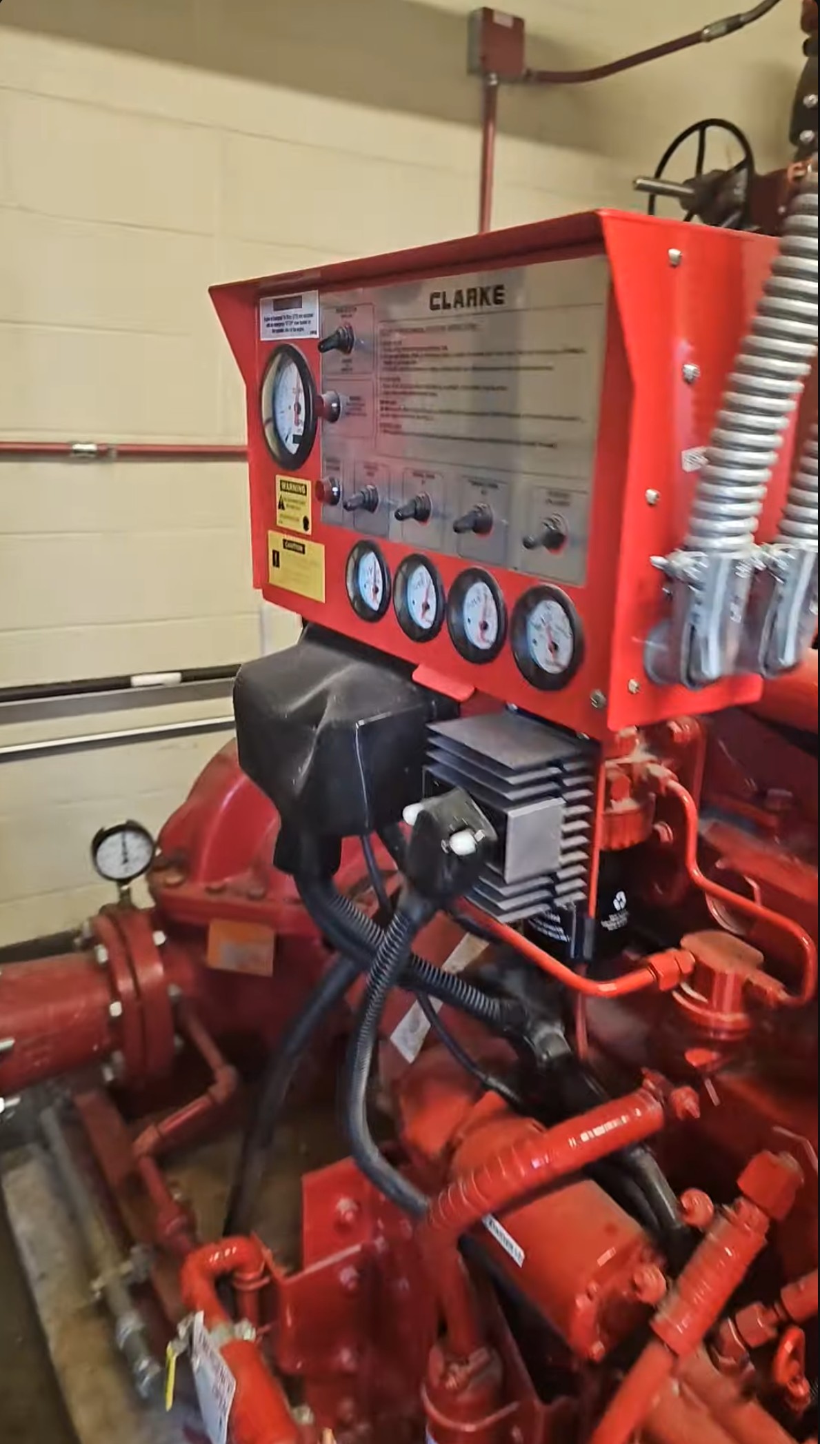 Clarke diesel fire pump engine gauge panel — tachometer, oil pressure, coolant temperature, battery voltage, and fuel level gauges with warning/caution labels