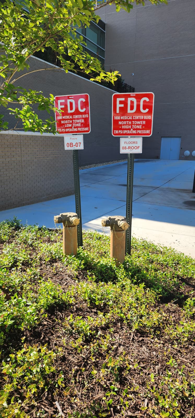 Pair of Fire Department Connections for a high-rise — one labeled LOW ZONE 175 PSI operating pressure, the other HIGH ZONE 238 PSI operating pressure, with floor-range signs for 0B-07 and 08-ROOF