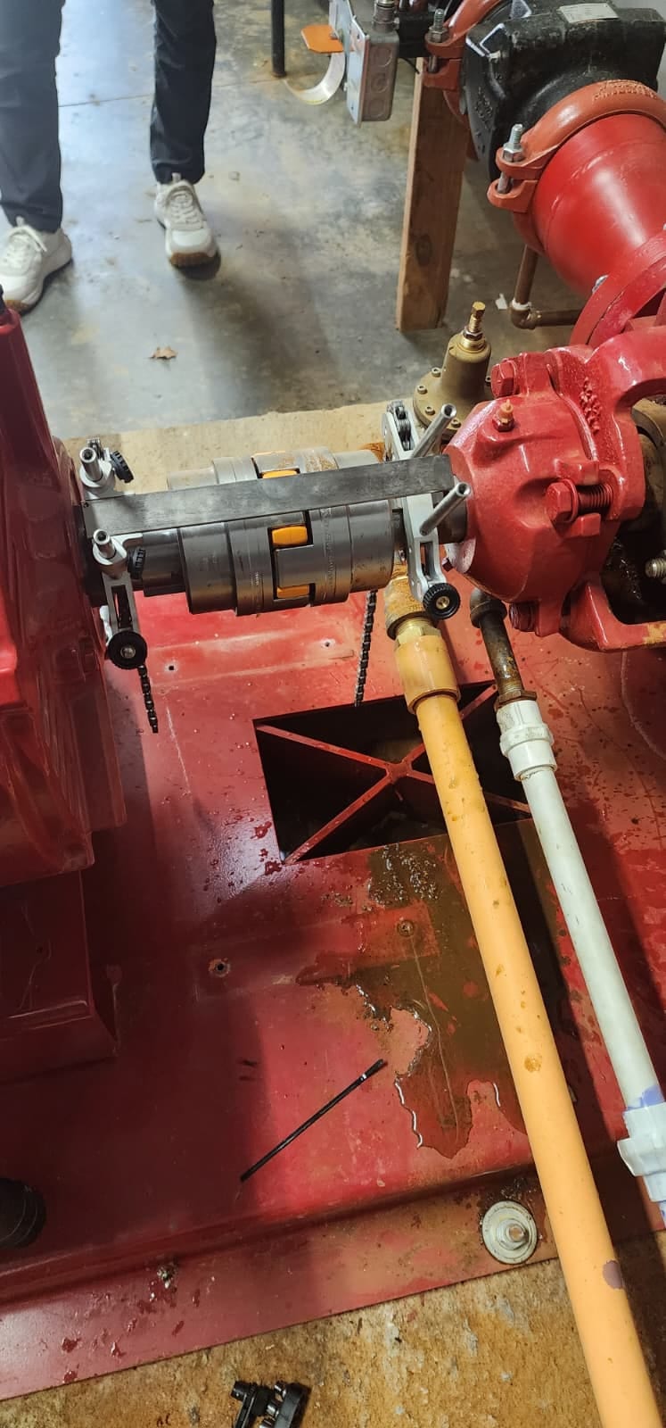Alignment brackets and straight edge mounted across the fire pump flexible coupling, seen from above
