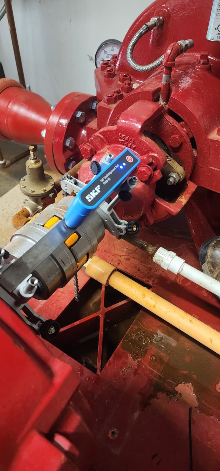 SKF TKSA 11 precision shaft alignment tool mounted with chain brackets on the fire pump shaft beside the flexible coupling