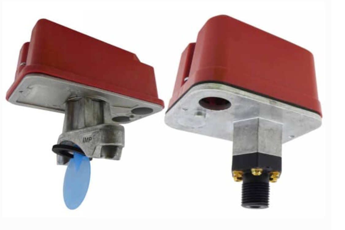 Side-by-side comparison — waterflow switch (left, with blue vane paddle) vs pressure switch (right, with threaded pipe connection). Both have red enclosures but completely different sensing mechanisms.