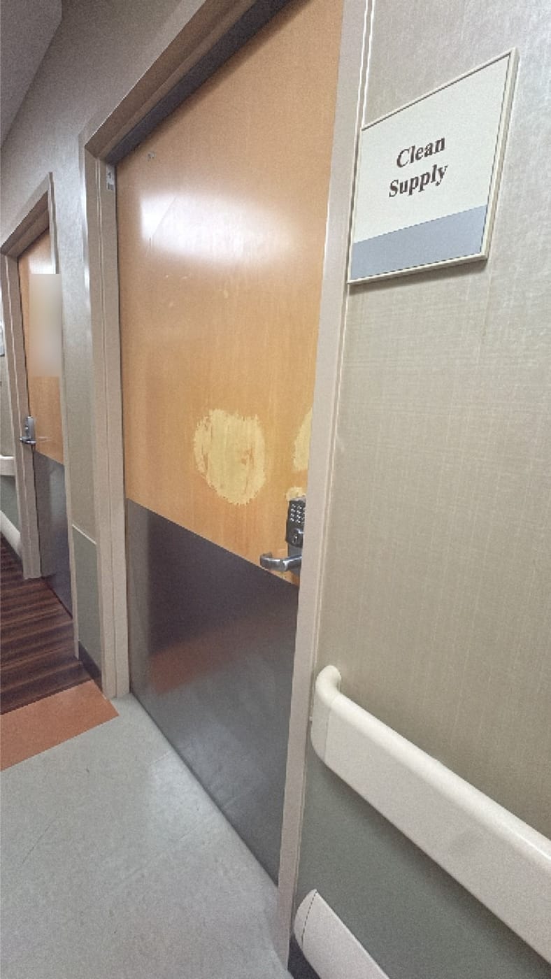 A clean supply room door with patches of worn, peeling surface finish