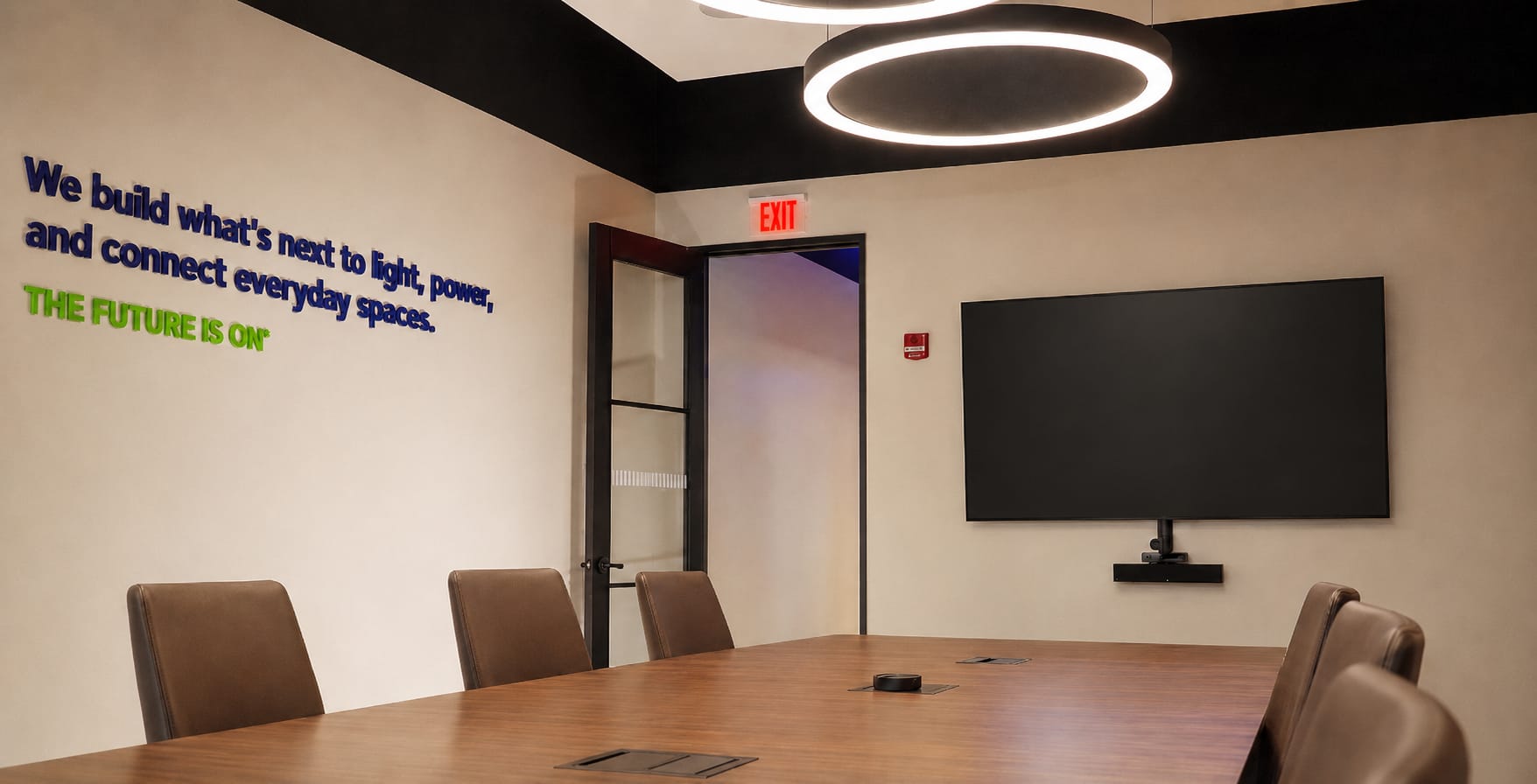 Leviton Nashville experience center boardroom with oval conference table and dual display screens