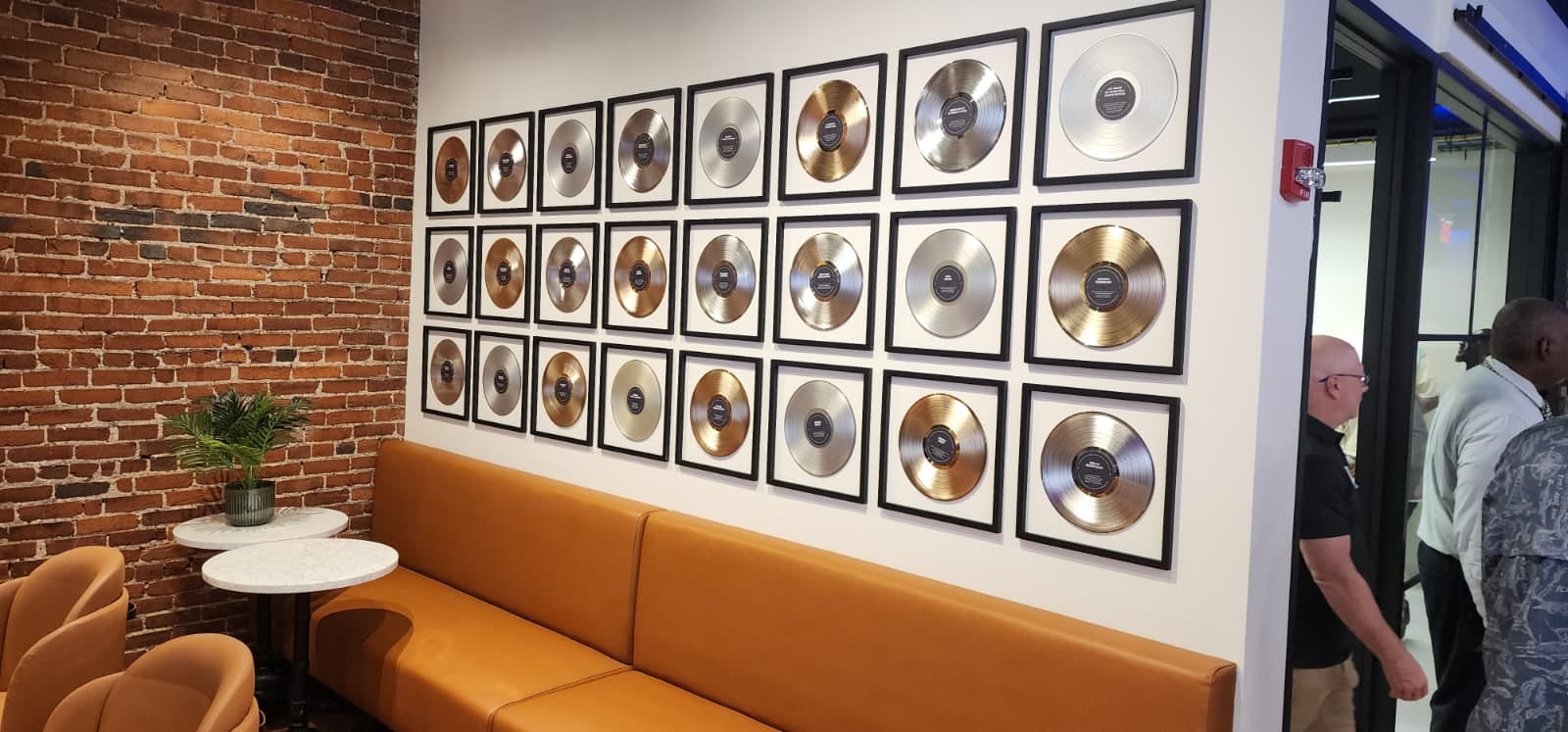 Safety professionals touring Leviton's Nashville experience center, a brick-walled space with a wall of framed gold and platinum records