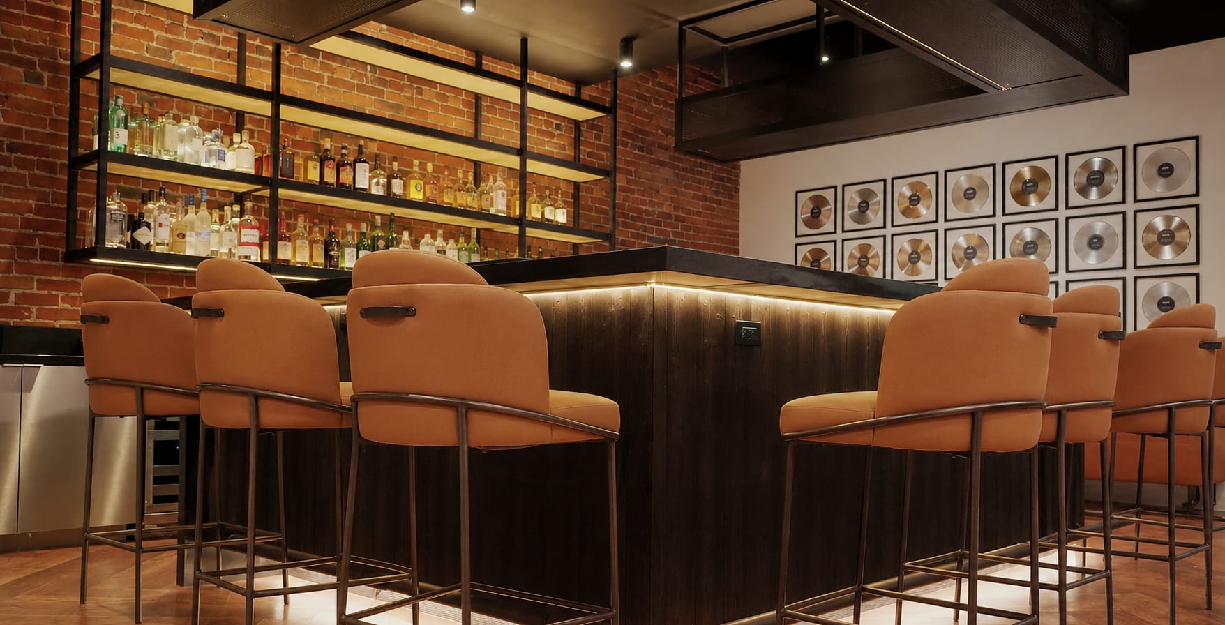 Leviton Nashville experience center lounge with exposed brick walls and a wall of gold and platinum records