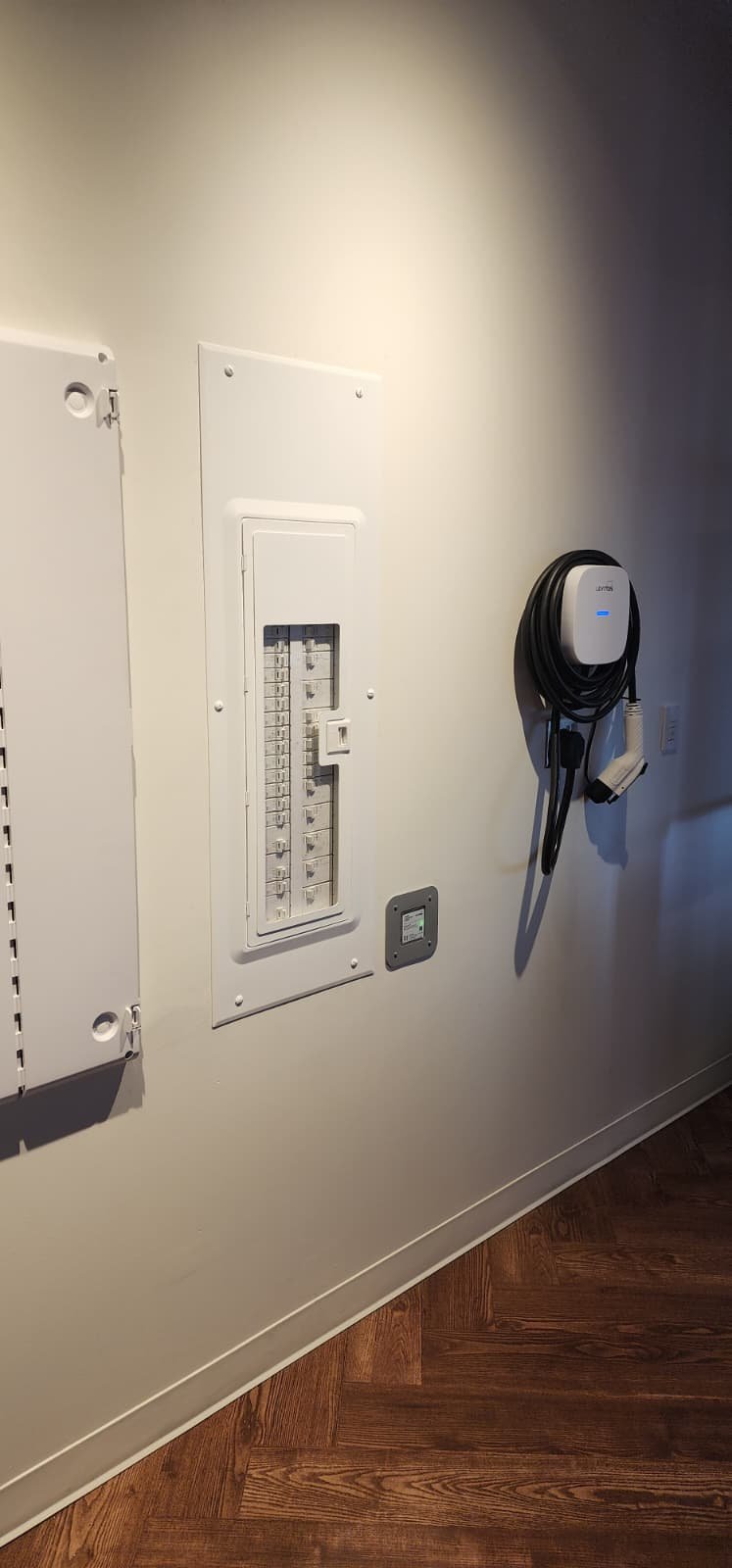 Leviton Smart Load Center with observation door open, showing rows of 2nd Gen Smart Circuit Breakers alongside a Leviton EV charging station at the Nashville experience center