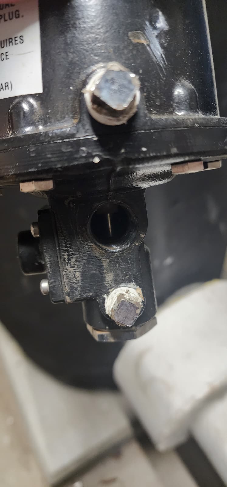 Close-up of accelerator lower valve body showing the connection port, bolts, and diaphragm housing