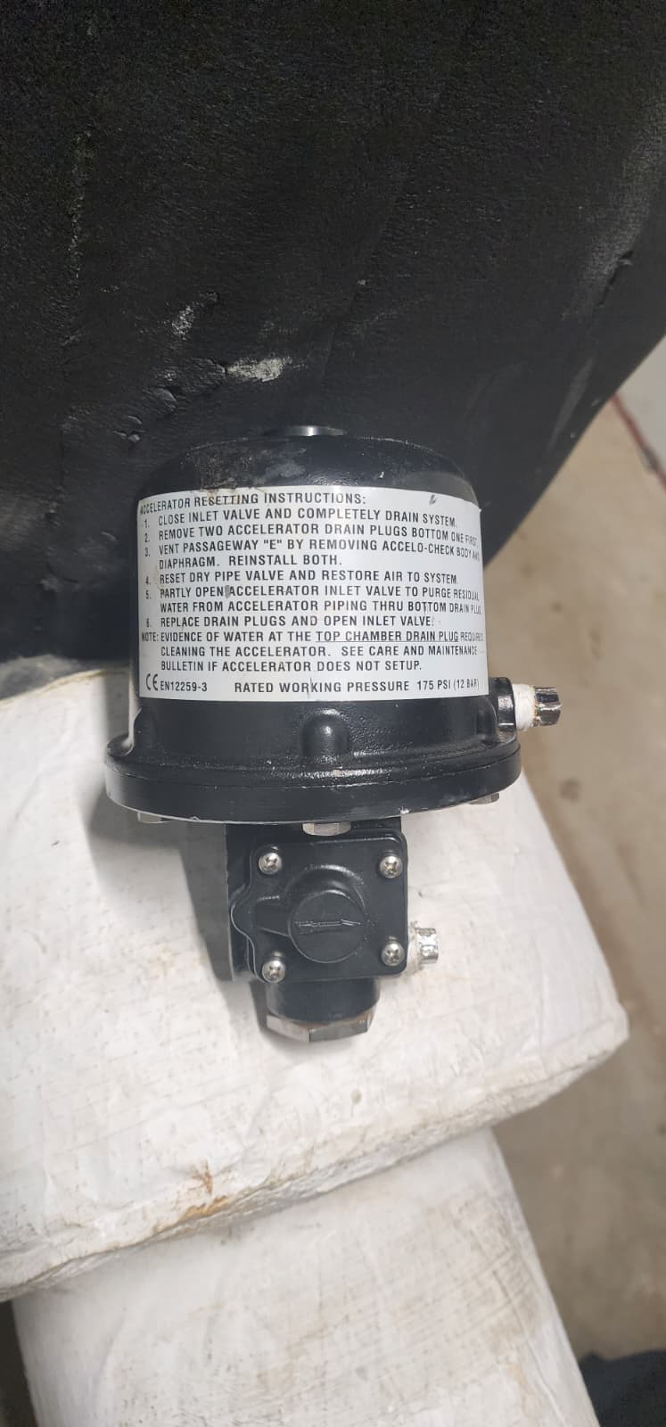 Accelerator reset instructions label showing 6-step procedure, CE EN12259-3, rated working pressure 175 PSI (12 BAR)