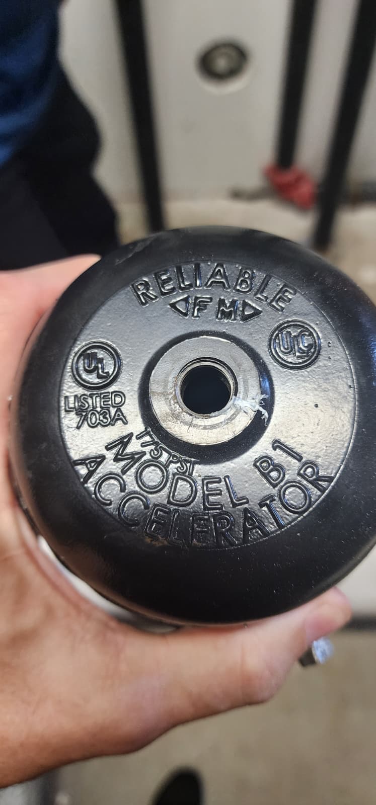 Bottom of Reliable Model B1 Accelerator showing cast markings: RELIABLE, FM, UL LISTED 703A, MODEL B1, ACCELERATOR, 175 PSI