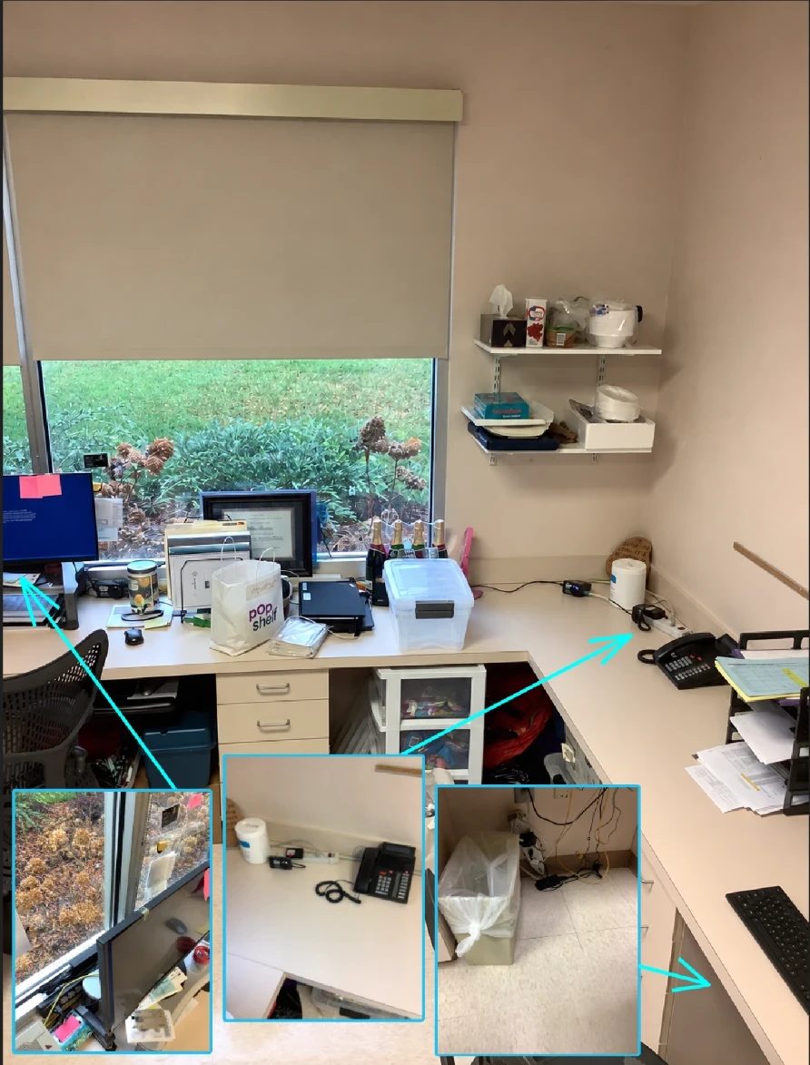 An office desk annotated with three arrows pointing to a monitor with a power strip near the floor, a corded phone and adapter tangle on the desk corner, and a trash-lined electrical panel area under the desk