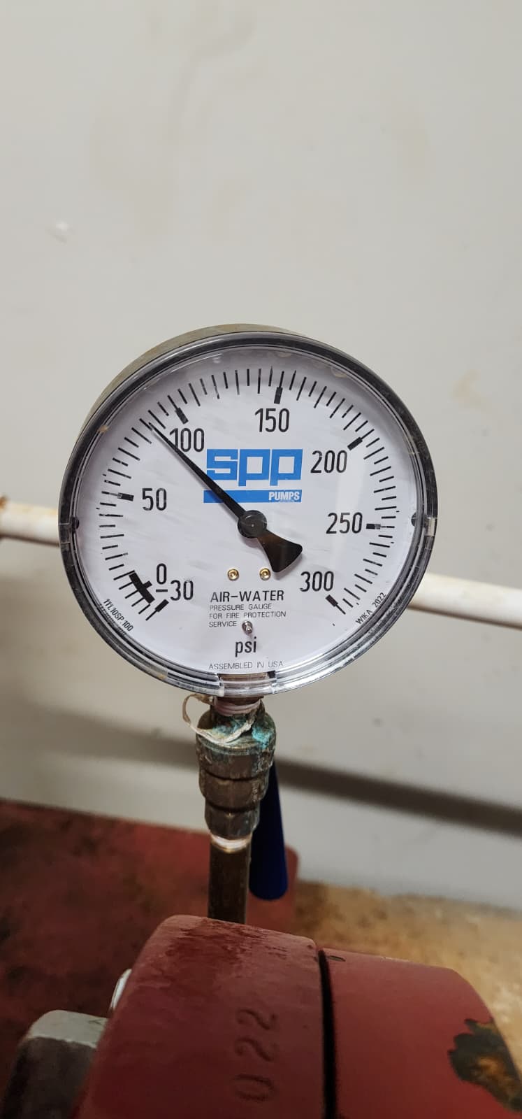 SPP Pumps air-water pressure gauge for fire protection service, 0–300 PSI range, reading approximately 110 PSI, mounted via brass fitting on a fire pump header