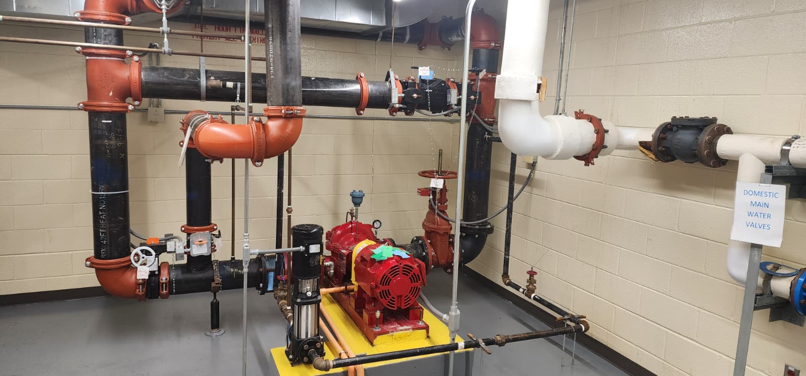 Wet sprinkler system riser assembly showing alarm check valve, gauges, and control valve