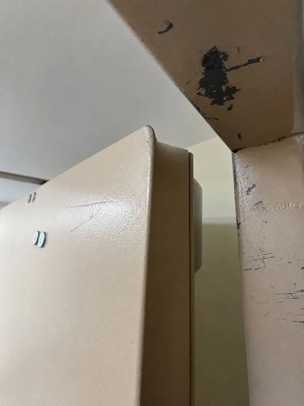 Close-up of a rated door edge and frame, scuffed and chipped from carts and traffic